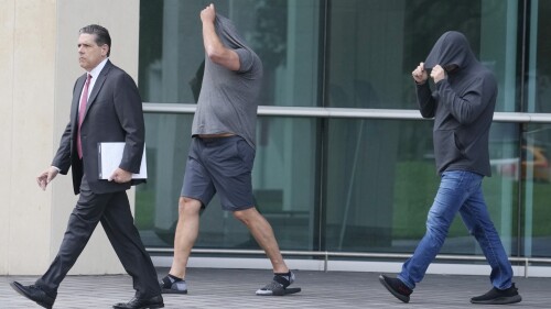 Michael Shvartsman, right, and his brother Gerald, center, leave the federal courthouse with their attorney, after posting bond, Thursday, June 29, 2023, in Miami. The two brothers and another man are charged with making $22 million through illegal insider trading before the public announcement of a Miami firm's merger with former President Donald Trump's media company. The charges do not implicate Trump or the Trump Media & Technology Group. (AP Photo/Marta Lavandier)