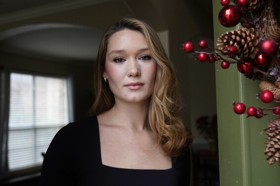 Nicole Plauché, 23, poses for a photo at her family's home in Highland Village, Texas, Friday, Dec. 15, 2023. Plauché graduated from college last year with a business degree and is navigating how to manage holiday spending while paying student loan debt. (AP Photo/LM Otero)