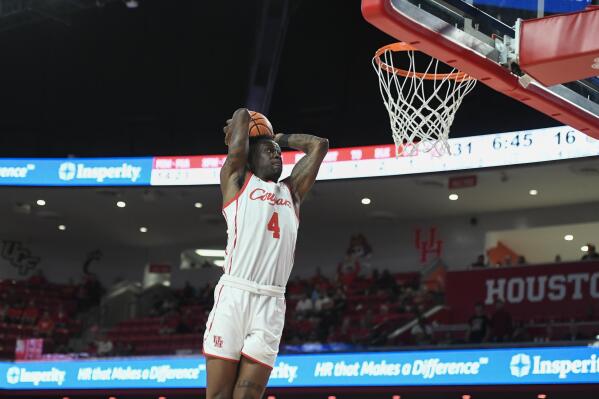 Houston guard Taze Moore (4) dunks against Bryant during the first half of an NCAA college basketball game Friday, Dec. 3, 2021, in Houston. (AP Photo/Justin Rex)