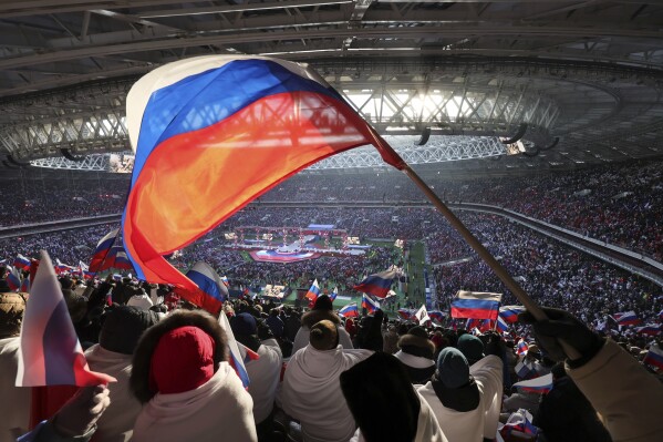 FILE - Participants wave Russian flags during the ''Glory to the Defenders of the Fatherland'' concert while waiting for President Vladimir Putin at the Luzhniki Stadium in Moscow, Russia, Wednesday, Feb. 22, 2023. (AP Photo, File)