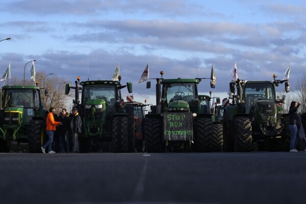 File - A book of reading that farmers discuss on their tractors "Stop on constraint" Wednesday, January 31, 2024, on a closed highway in Chilly-Mazarin, south of Paris.  (AP Photo/Christophe Ena, File)
