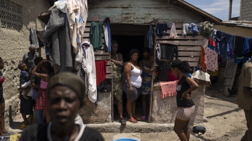 People displaced by gang violence stand in Jean-Kere Almicar's front yard, where they have sought refuge, in Port-au-Prince, Haiti, Sunday, June 4, 2023. Nearly 200 people who once lived in the Cite Soleil slum near Almicar’s house are now camped out in his front yard and nearby areas. They are among the nearly 165,000 Haitians who have fled their homes amid a surge in gang violence. (AP Photo/Ariana Cubillos)
