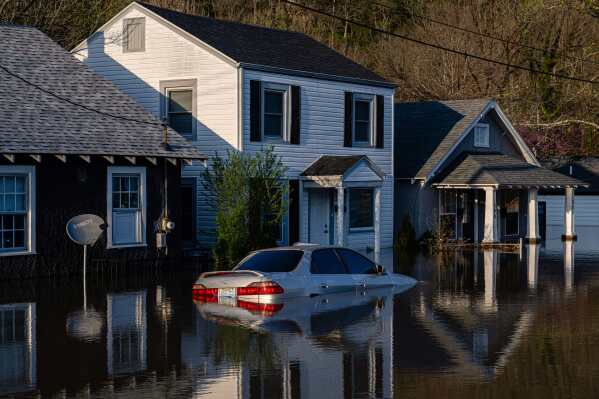 A vehicle sits in a flooded neighborhood on Monday, April 7, 2025, in Frankfort, Ky. (AP Photo/Jon Cherry)