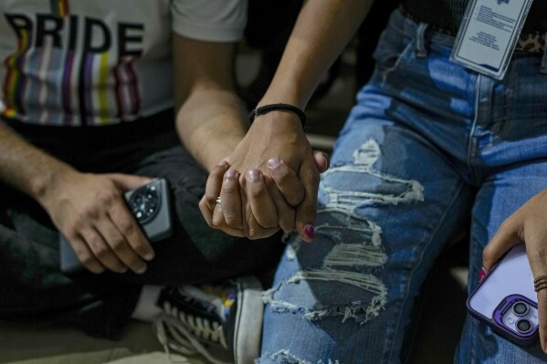 LGBTQ community supporters and members hold each other hand as they watch the Supreme Court verdict on petitions that seek the legalization of same-sex marriage, in Mumbai, India, Tuesday, Oct. 17, 2023. According to a Pew survey, acceptance of homosexuality in India increased by 22 percentage points to 37% between 2013 and 2019. (AP Photo/Rafiq Maqbool)