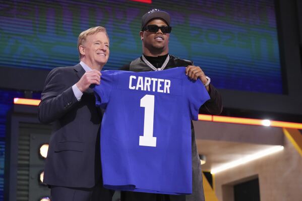 Penn State defensive end Abdul Carter, right, poses with NFL Commissioner Roger Goodell after being chosen by the New York Giants with the third overall pick during the first round of the NFL football draft, Thursday, April 24, 2025, in Green Bay, Wis. (AP Photo/Jeff Roberson)