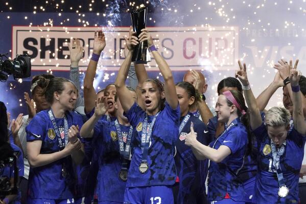 United States forward Alex Morgan, center, lifts the SheBelieves Cup with teammates after they won a soccer match against Brazil 2-0 Wednesday, Feb. 22, 2023, in Frisco, Texas. (AP Photo/LM Otero)