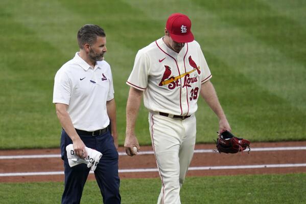 St. Louis Cardinals starting pitcher Miles Mikolas, right, walks off with trainer Adam Olsen the field before the start of the fifth inning of a baseball game against the Chicago Cubs Saturday, May 22, 2021, in St. Louis. Mikolas walked out to the field at the top of the inning but left before the start. (AP Photo/Jeff Roberson)