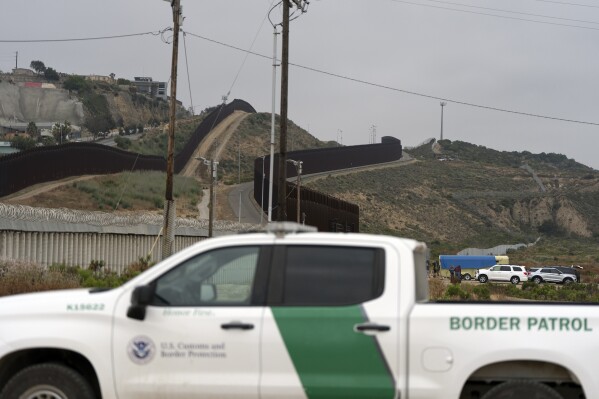 A Border Patrol vehicle sits near border walls separating Tijuana, Mexico, from the United States, Tuesday, June 4, 2024, in San Diego. President Joe Biden has unveiled plans to enact immediate significant restrictions on migrants seeking asylum at the U.S.-Mexico border as the White House tries to neutralize immigration as a political liability ahead of the November elections. (AP Photo/Gregory Bull)