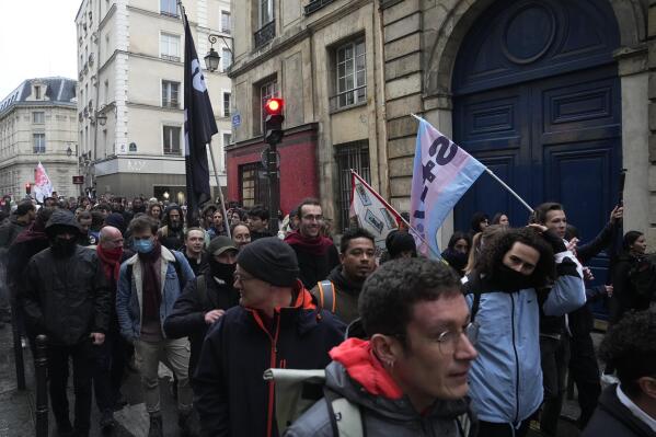 Demonstrators march during a protest, Friday, April 14, 2023 in Paris. France's Constitutional Council on Friday approved an unpopular plan to raise the retirement age from 62 to 64, in a victory for President Emmanuel Macron after three months of mass protests over the legislation that have damaged his leadership. The decision dismayed or enraged critics of the pension plan, including protesters gathered outside Paris City Hall as the decision came down. (AP Photo/Michel Euler)