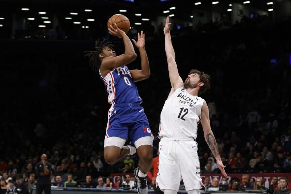 Philadelphia 76ers' Tyrese Maxey (0) shoots against Brooklyn Nets' Joe Harris (12) during the first quarter of an NBA basketball game Saturday, Feb. 11, 2023, in New York. (AP Photo/Jason DeCrow)