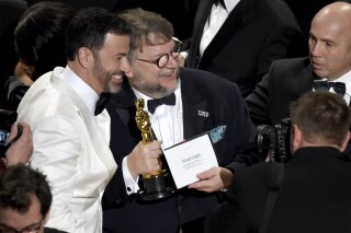 
              Jimmy Kimmel, left, congratulates Guillermo del Toro in the audience after winning the award for best picture for "The Shape of Water" at the Oscars on Sunday, March 4, 2018, at the Dolby Theatre in Los Angeles. (Photo by Chris Pizzello/Invision/AP)
            