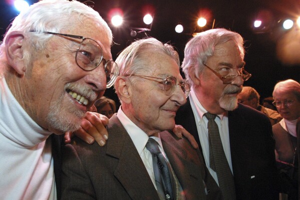 FILE - Lore Noto, the original producer of the off-Broadway musical "The Fantasticks," is flanked by the plays authors Tom Jones, left, and Harvey Schmidt, Sunday, Jan. 13, 2002, at the tiny Sullivan Street Playhouse in New York's Greenwich Village. Jones, the lyricist, director and writer of “The Fantasticks,” the longest running musical in history, which made its 1960 debut when Dwight D. Eisenhower was still president and closed in 2017, died Friday, Aug. 11, 2023. He was 95. (AP Photo/Tina Fineberg, File)