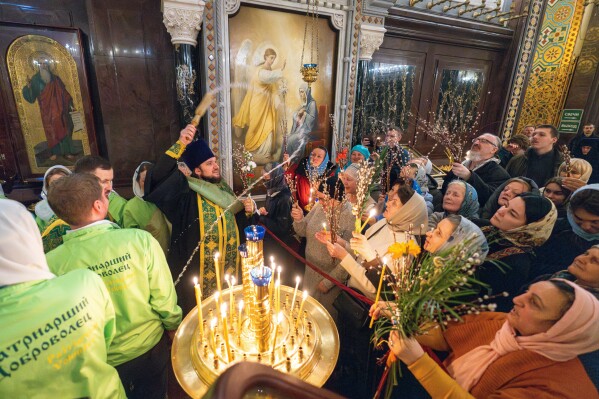 In this photo released by Russian Orthodox Church Press Service on Saturday, April 12, 2025, an Orthodox priest blesses parishioners after an Orthodox religion service on eve of celebrating the Palm Sunday in the Christ the Savior Cathedral in Moscow, Russia. (Oleg Varov/Russian Orthodox Church Press Service via AP)