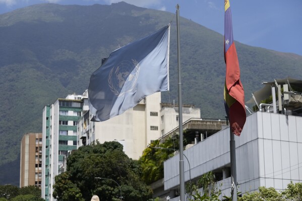 A U.N. and Venezuelan flag hang outside the building that houses the Technical Advisory Office of the United Nations High Commissioner for Human Rights, in Caracas, Venezuela, Thursday, Feb. 15, 2024. Venezuela's government on Thursday ordered this local U.N. office on human rights to suspend operations and gave its staff 72 hours to leave, accusing the office of promoting opposition to the South American country. (APPhoto/Matias Delacroix)