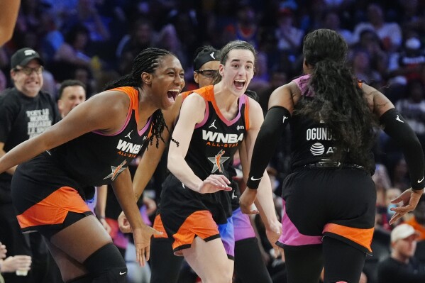 Arike Ogunbowale, right, of Team WNBA, celebrates after her 3-point basket against Team USA with teammates Caitlin Clark, center, and Aliyah Boston, left, during the second half of a WNBA All-Star basketball game Saturday, July 20, 2024, in Phoenix. (ĢӰԺ Photo/Ross D. Franklin)