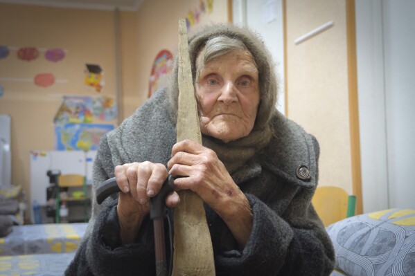 In this photo provided by the Ukrainian National Police of Donetsk region, 98-year-old Lidia Lomikovska sits in a shelter after she escaped Russian-occupied territory in the Donetsk region, Ukraine, April 26, 2024. Lomikovska left the frontline town of Ocheretyne last week by walking almost 10 km (6 miles) alone, after Russian troops entered it and fighting intensified. (Ukrainian National Police of Donetsk region via AP)