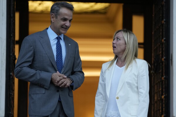 Greece's Prime Minister Kyriakos Mitsotakis, left, welcomes his Italian counterpart Giorgia Meloni at Maximos Mansion in Athens, Greece, Thursday, Aug. 31, 2023. Meloni is visiting the Greek capital to discuss stability pact and migration. (AP Photo/Thanassis Stavrakis)