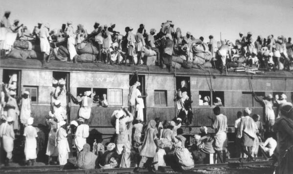 FILE - Muslim refugees sit on the roof of an overcrowded coach railway train in trying to flee India near New Delhi on Sept. 19, 1947. About 5 million Muslims migrated from India to Pakistan after India gained its independence on Aug. 15. (AP Photo/File)
