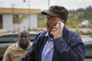 FILE - Lead Tigray negotiator Getachew Reda speaks on his phone at Ethiopian peace talks in Nairobi, Kenya Saturday, Nov. 12, 2022. Reda tweeted Wednesday, Jan. 11, 2023, that the Tigray forces have handed over heavy weapons as a key part of the agreement signed with Ethiopia’s government late last year to end a two-year conflict. (AP Photo/Brian Inganga, File)