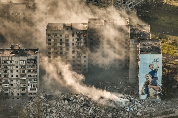 Smoke rises from a building in Bakhmut, the site of the heaviest battles with the Russian troops in the Donetsk region, Ukraine, Wednesday, April 26, 2023. (AP Photo/Libkos)