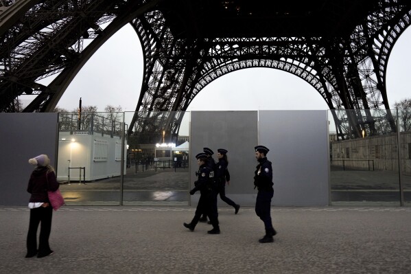 French policemen patrol near the Eiffel Tower, in Paris, Thursday, Dec. 7, 2023. Less than a year before the 2024 Paris Olympic Games, with an opening ceremony on the nearby Seine river, the bar was already high. But the security challenge went up with the deadly weekend knife attack that killed a tourist near the Eiffel Tower, a tourist magnet that is the symbol of Paris. (APPhoto/Thibault Camus)