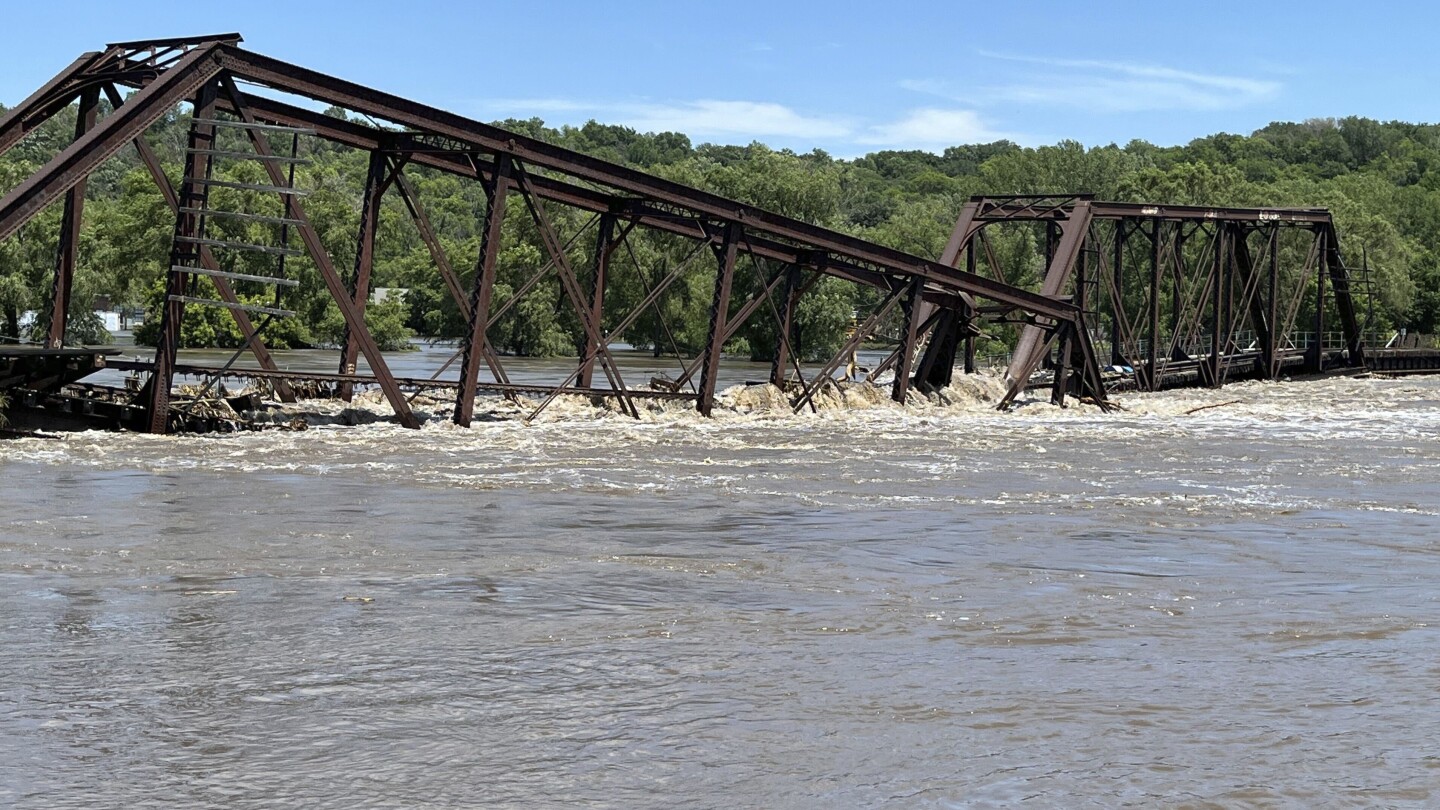 Flooding in the Midwest causes bridge to collapse and water to flow around a dam