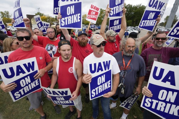 United Auto Workers members hold picket signs near a General Motors Assembly Plant in Delta Township, Mich., Friday, Sept. 29, 2023. The UAW union expanded its two-week strikes against Detroit automakers Friday, adding 7,000 workers at a Ford plant in Chicago and a General Motors assembly factory near Lansing, Michigan. (AP Photo/Paul Sancya)