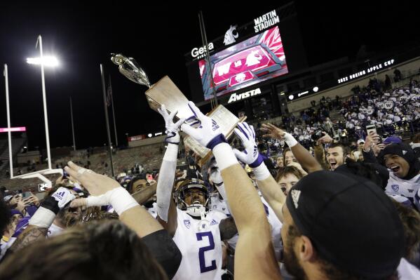 Washington players celebrate with the Apple Cup Trophy after their 51-33 win against Washington State in an NCAA college football game, Saturday, Nov. 26, 2022, in Pullman, Wash. (AP Photo/Young Kwak)