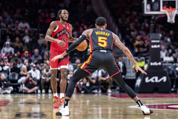 Toronto Raptors guard Immanuel Quickley (5) brings the ball down court during while being guarded by Atlanta Hawks guard Dejounte Murray (5) the first half of an NBA basketball game, Friday, Feb. 23, 2024, in Atlanta. (AP Photo/Jason Allen)