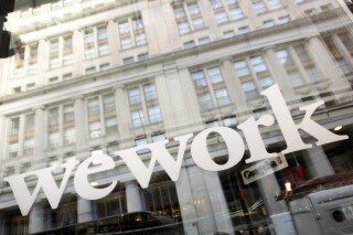 FILE - The WeWork logo is seen at one of the company's offices, Jan. 16, 2020, in New York. WeWork expects to emerge from bankruptcy by the end of May 2024, the embattled co-working space provider said this week, as the company pointed to lease restructuring efforts set to bring in an estimated $8 billion in future rental savings. In an update Tuesday, April 2, 2024, WeWork said it had “determined a final path forward” 90% of the locations in the company's global real estate portfolio. (AP Photo/Mark Lennihan, File)
