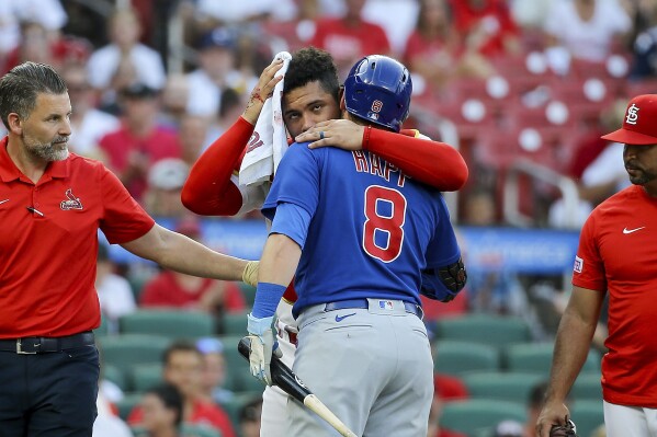 St. Louis Cardinals catcher Willson Contreras embraces Chicago Cubs' Ian Happ as Contreras leaves the game after being hit by Happ's bat during the first inning of a baseball game Thursday, July 27, 2023, in St. Louis. (AP Photo/Scott Kane)