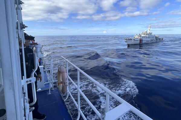 A Chinese coast guard vessel maneuvers beside the Philippine coast guard ship BRP Cabra as they approach Second Thomas Shoal, locally known as Ayungin Shoal, during a resupply mission at the disputed South China Sea on Friday Nov. 10, 2023. (AP Photo/Jim Gomez)