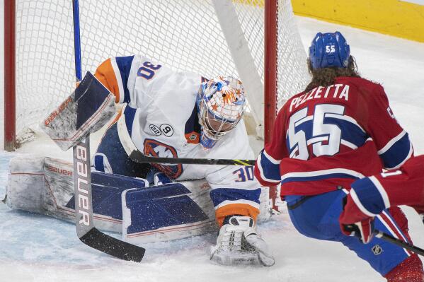 Montreal Canadiens' Michael Pezzetta, right, moves in against New York Islanders goaltender Ilya Sorokin during second-period NHL hockey game action in Montreal, Friday, April 15, 2022. (Graham Hughes/The Canadian Press via AP)