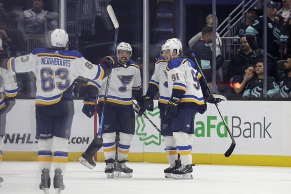 St. Louis Blues left wing Jake Neighbours (63), defenseman Justin Faulk (72), right wing Vladimir Tarasenko (91) and others celebrate the team's 4-3 overtime win over the Seattle Kraken in an NHL hockey game, Wednesday, Oct. 19, 2022, in Seattle. (AP Photo/John Froschauer)