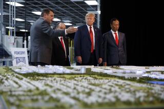 FILE - In this June 28, 2018 photo, President Donald Trump takes a tour of Foxconn with Foxconn chairman Terry Gou, right, and CEO of SoftBank Masayoshi Son in Mt. Pleasant, Wis.  Foxconn Technology Group will qualify for up to $80 million in state tax incentives under a new contract agreed to on Tuesday, April 20, 2021 that downsizes the scale of credits as the size of the envisioned manufacturing facility has also shrunk. Gov. Tony Evers announced details of the new contract.  (AP Photo/Evan Vucci, File)