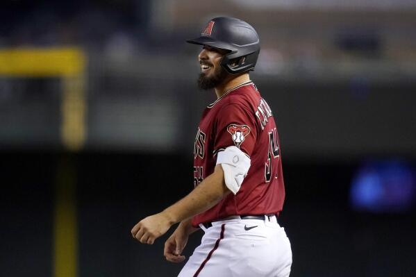 Arizona Diamondbacks' Humberto Castellanos smiles as he stands at first base after hitting a run-scoring single against the Philadelphia Phillies during the fourth inning of a baseball game, Wednesday, Aug. 18, 2021, in Phoenix. (AP Photo/Ross D. Franklin)