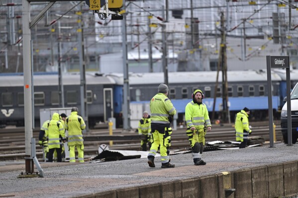 Workers remove a piece of roof that was blown off by strong winds at the main train station in Goteborg, Sweden, Friday, Feb. 23, 2024, causing no injuries but knocking out power and stopping all rail traffic in and out of Sweden鈥檚 second largest city. (Bj枚rn Larsson Rosvall/TT News Agency via AP)