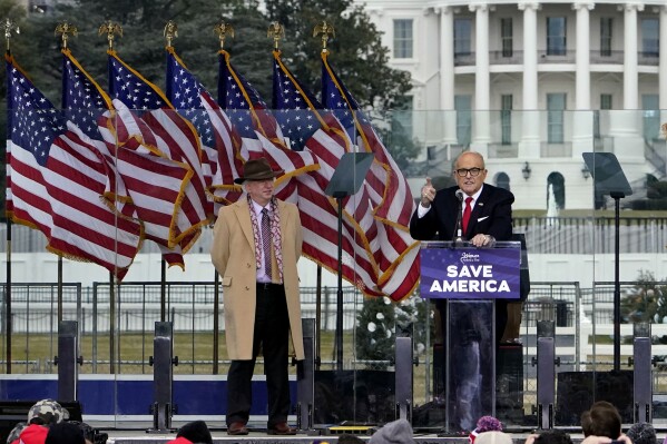 FILE - Chapman University law professor John Eastman stands at left as former New York Mayor Rudolph Giuliani speaks in Washington at a rally in support of President Donald Trump, called the "Save America Rally" on Jan. 6, 2021. The 18 defendants charged alongside Trump in this month's racketeering indictment in Fulton County include more than a half-dozen lawyers, and the statements from Eastman and Giuliani provide early foreshadowing of at least one of the defenses they seem poised to raise: that they were merely doing their jobs as attorneys when they maneuvered on Trump's behalf to undo the results of that election. (AP Photo/Jacquelyn Martin, File)