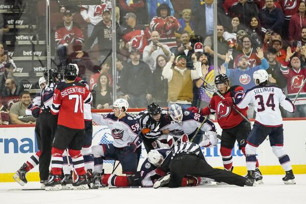 New Jersey Devils and Columbus Blue Jackets players fight for the puck during the second period of an NHL hockey game Sunday, Oct. 30, 2022, in Newark, N.J. (AP Photo/Eduardo Munoz Alvarez)