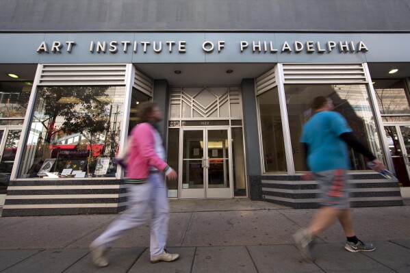 FILE - People walk past the Art Institute of Philadelphia operated by the Education Management Corporation on Nov. 16, 2015, in Philadelphia. The Biden administration on Wednesday said it will cancel $6 billion in student loans for people who attended the Art Institutes, a system of for-profit colleges that closed the last of its campuses in 2023 amid accusations of fraud. (AP Photo/Matt Rourke, File)