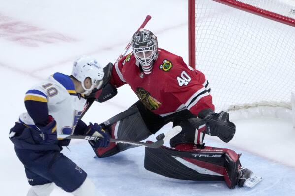 St. Louis Blues' Brayden Schenn (10) is unable to get control of the airborne puck as Chicago Blackhawks goaltender Arvid Soderblom defends during the third period of an NHL hockey game Wednesday, Nov. 16, 2022, in Chicago. The Blues won 5-2. (AP Photo/Charles Rex Arbogast)