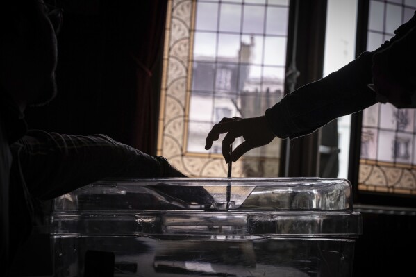 A voter casts a ballot at a polling station for the first round of the parliamentary elections in Paris, Sunday, June 30, 2024. (AP Photo/Aurelien Morissard)