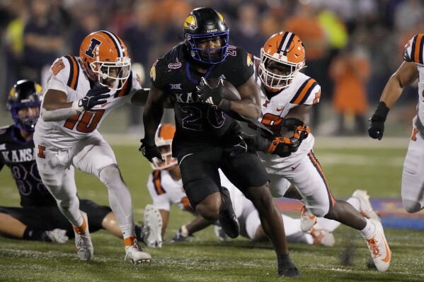 Kansas running back Daniel Hishaw Jr. (20) is chased by Illinois defensive back Miles Scott (10) and linebacker Seth Coleman (49) during the second half of an NCAA college football game Friday, Sept. 8, 2023, in Lawrence, Kan. Kansas won 34-23. (AP Photo/Charlie Riedel)
