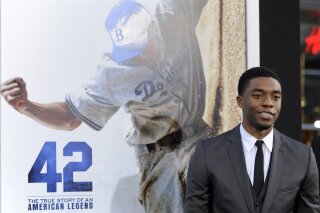 FILE - In this Tuesday, April 9, 2013 file photo, Chadwick Boseman, who plays baseball legend Jackie Robinson in "42," poses at the Los Angeles premiere of the film at the TCL Chinese Theater in Los Angeles. Actor Chadwick Boseman, who played Black icons Jackie Robinson and James Brown before finding fame as the regal Black Panther in the Marvel cinematic universe, has died of cancer. His representative says Boseman died Friday, Aug. 28, 2020 in Los Angeles after a four-year battle with colon cancer. He was 43. (Photo by Chris Pizzello/Invision/AP, File)