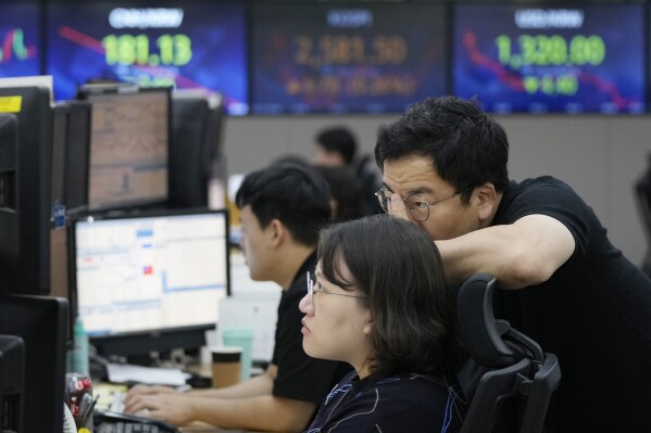 FILE - Currency traders watch monitors at the foreign exchange dealing room of the KEB Hana Bank headquarters in Seoul, South Korea, on Sept. 19, 2023. Asian shares were mostly lower Thursday, Sept. 28, in subdued trading on looming worries about China property woes. (AP Photo/Ahn Young-joon, File)