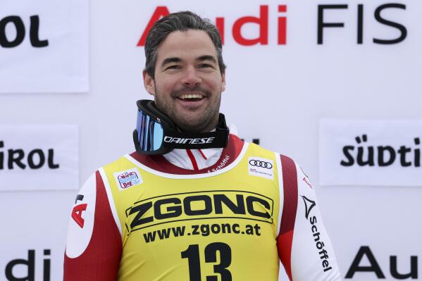 Austria's Vincent Kriechmayr celebrates on the podium after winning an alpine ski, men's World Cup downhill race, in Val Gardena, Italy, Thursday, Dec.15, 2022. (AP Photo/Alessandro Trovati)