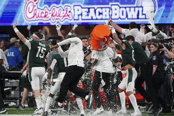 The Michigan State team celebrates a victory over Pittsburgh after the Peach Bowl NCAA college football game, Thursday, Dec. 30, 2021, in Atlanta. Michigan State won 31-21.(AP Photo/John Bazemore)