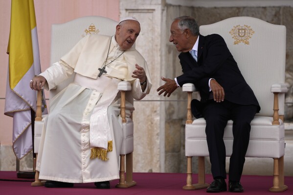 Pope Francis and Portugal's President Marcelo Rebelo de Sousa, right, converse at the Welcome Ceremony at the Belem presidential palace in Lisbon, Wednesday, Aug. 2, 2023. Pope Francis starts his five-day pastoral visit to Portugal Wednesday that includes his participation at the 37th World Youth Day, and a pilgrimage to the holy shrine of Fatima. (AP Photo/Armando Franca)