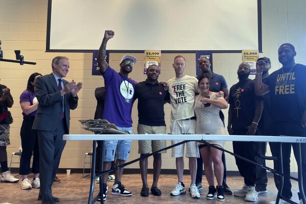 FILE - Minnesota Democratic Secretary of State Steve Simon, left, claps after registering newly eligible voters, June 1, 2023, at Arlington Hills Community Center in St. Paul, Minn. A Minnesota appeals court on Thursday, Nov. 2, stepped in to protect voting rights recently granted to felons under a new law, undoing a pro-Trump judge's effort to strip two convicts of their right to vote. (AP Photo/Trisha Ahmed, File)