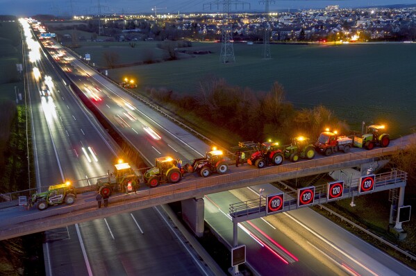 FILE - Farmers park their tractors on a small bridge over a highway in Frankfurt, Germany, Friday, Jan. 26, 2024. Farmers are protesting against government plans to scrap tax breaks on the diesel they use.  (AP Photo/Michael Probst, File)